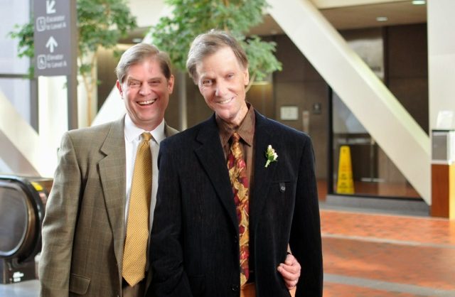 Photo of two white men in jackets and ties.